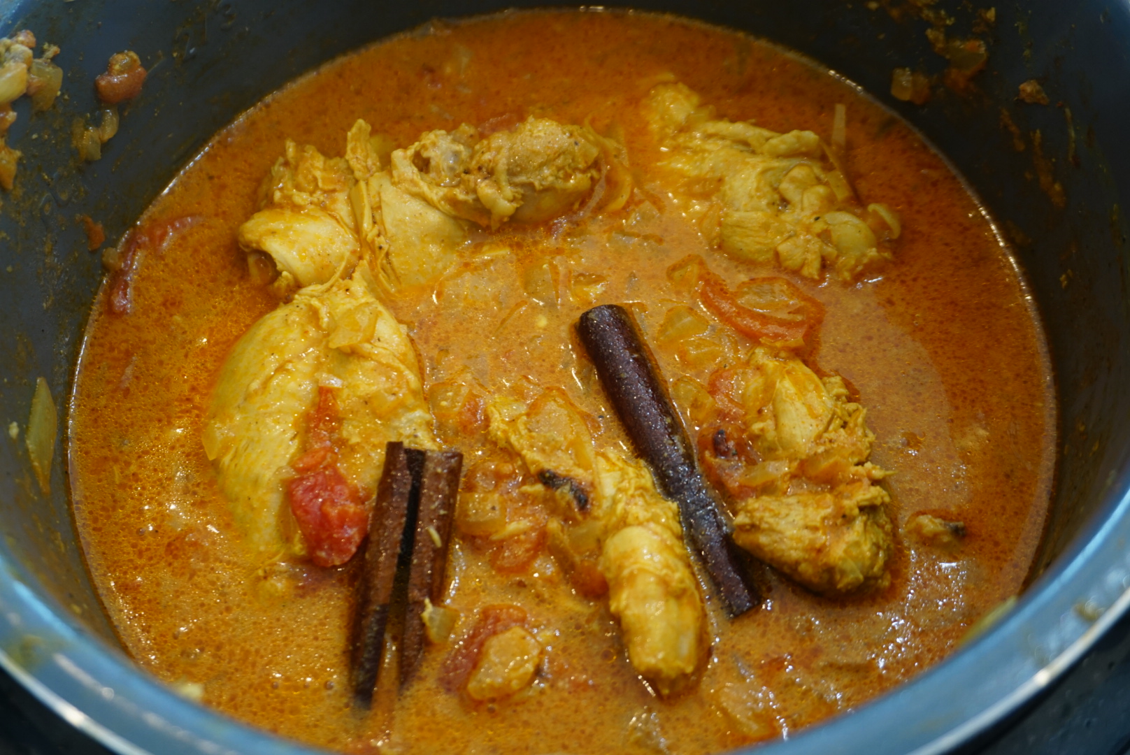 Chicken in a pressure cooker with tomatoes and spices